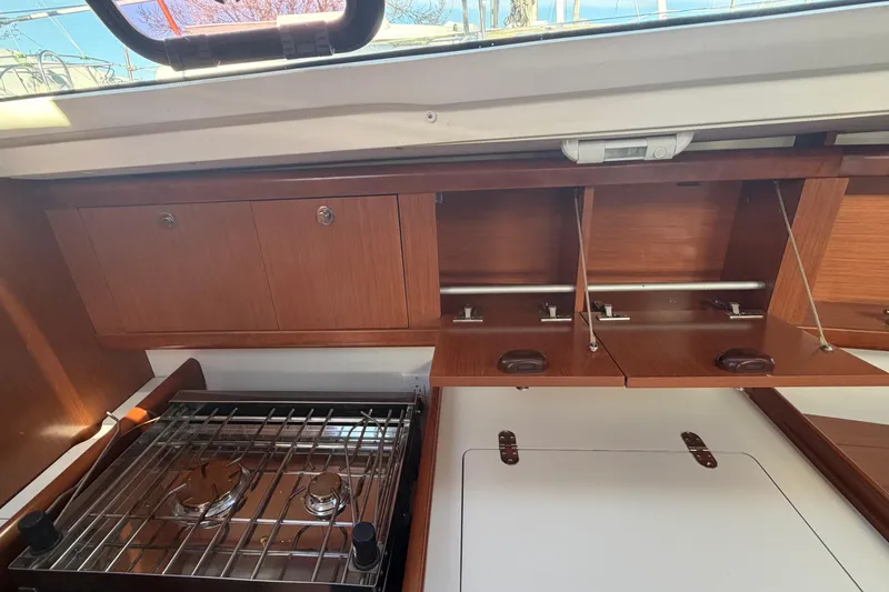 Slide: The Image of Interior view of 2008 Beneteau 31 sailboat kitchen with stove and wooden cabinets. - 39
