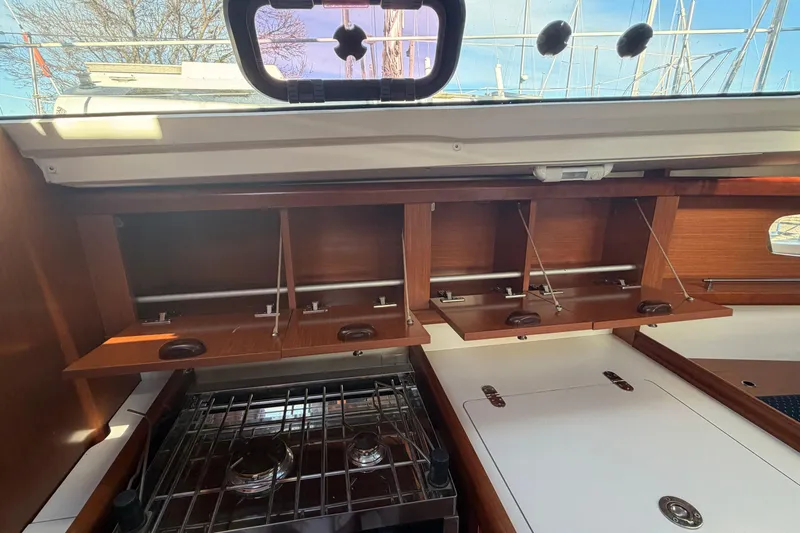 Slide: The Image of Interior view of 2008 Beneteau 31 sailboat kitchen with stove and wooden cabinets. - 40