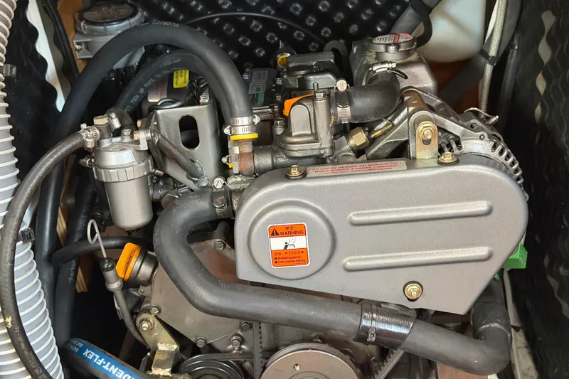 Slide: The Image of Engine compartment of a 2008 Beneteau 31 sailboat, showcasing mechanical components and hoses. - 62