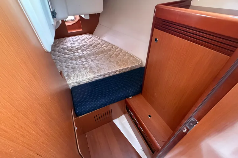 Slide: The Image of 2008 Beneteau 31 yacht interior cabin with wooden finish and cozy bedding. - 63