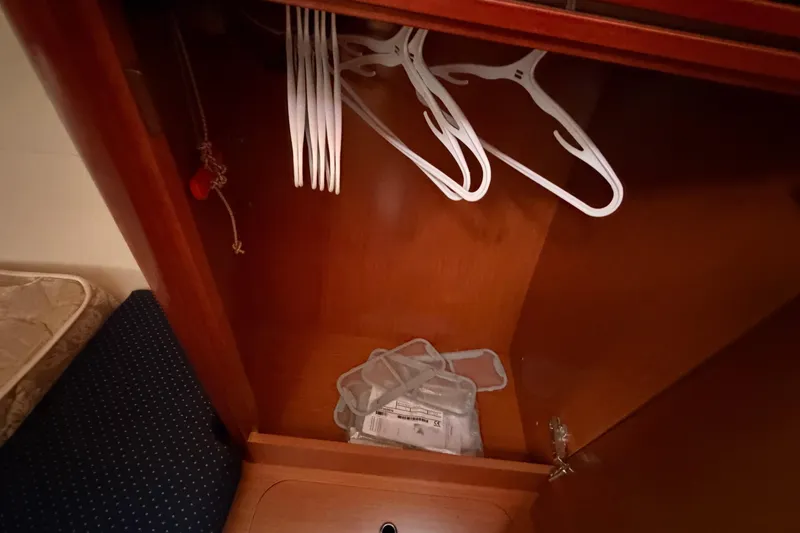 Slide: The Image of Wooden closet interior with hangers in a 2008 Beneteau 31 sailboat. - 64