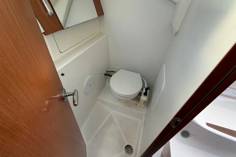 Slide: The Image of Compact bathroom in 2008 Beneteau 31 sailboat with toilet and wooden door. - 67
