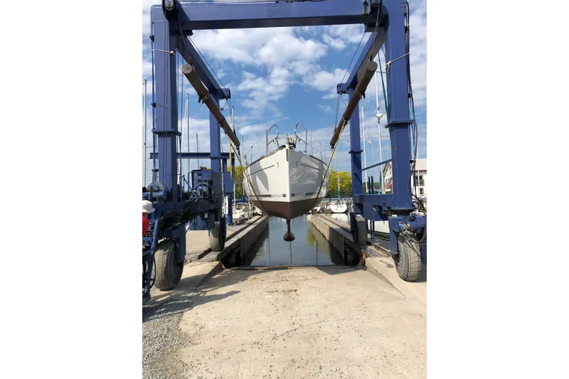 Slide: The Image of 2008 Beneteau 31 sailboat being lifted by a boat hoist at a marina. - 78