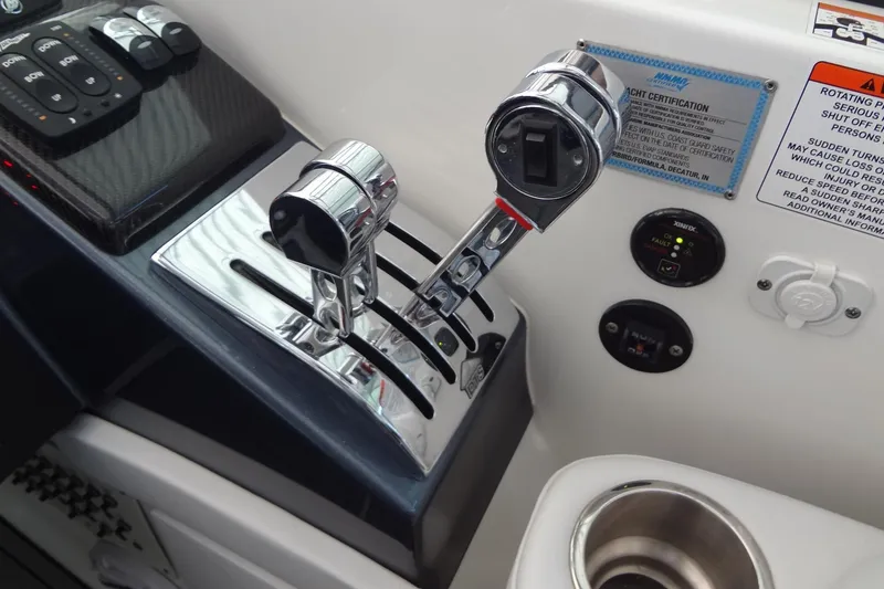 Slide: The Image of 2019 Formula 400 Super Sport boat controls with chrome throttle levers and dashboard switches. - 15