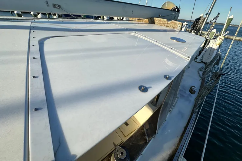 Slide: The Image of 1978 CSY 44 Cutter Rig sailboat deck, featuring sleek design and ocean backdrop. - 10