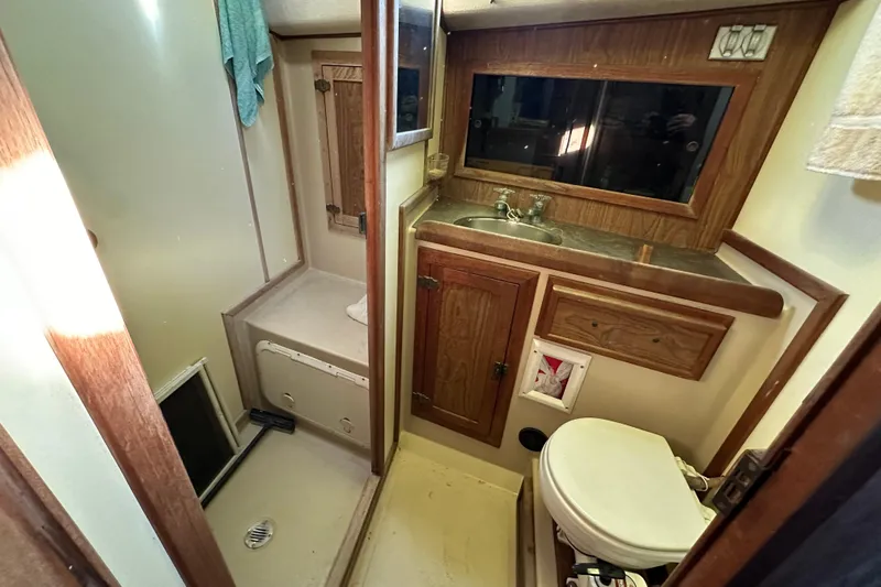 Slide: The Image of 1978 CSY 44 Cutter Rig bathroom with sink, toilet, and wooden cabinetry. - 18