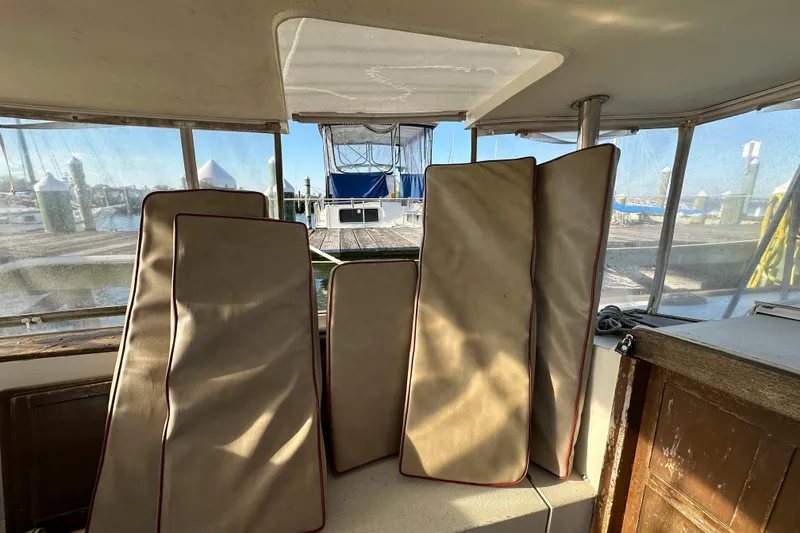 Slide: The Image of Interior view of 1978 CSY 44 Cutter Rig with cushions and marina background. - 32