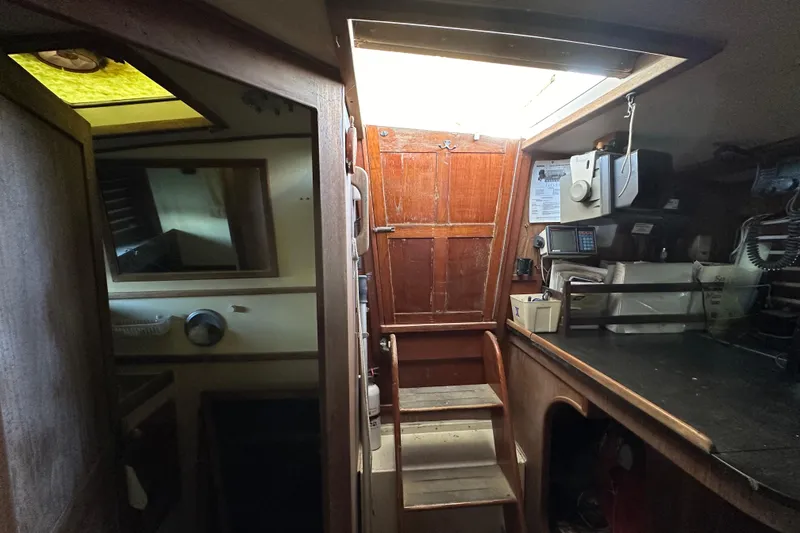Slide: The Image of Interior of 1978 CSY 44 Cutter Rig sailboat, featuring wooden stairs and navigation equipment. - 38