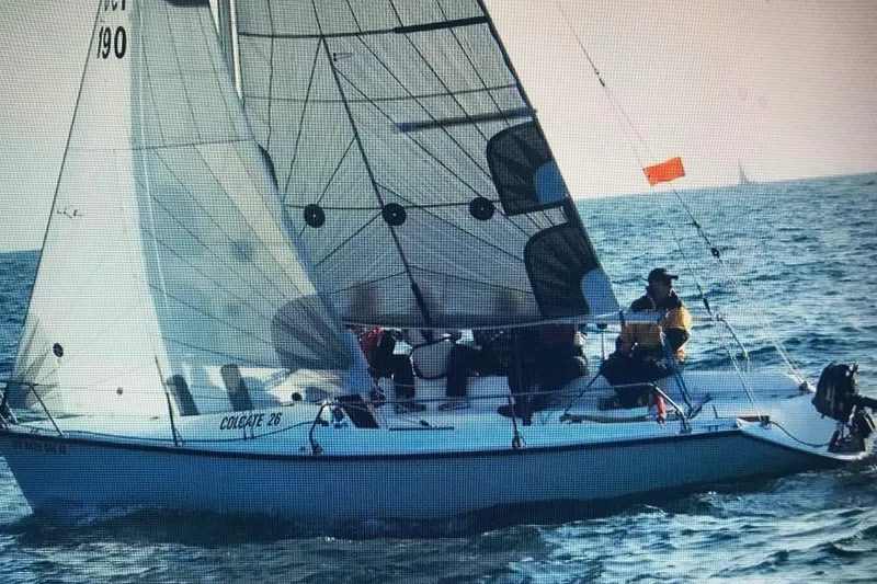 Slide: The Image of Sailboat Colgate 26, 2004 model, navigating ocean waters with crew onboard. - 1