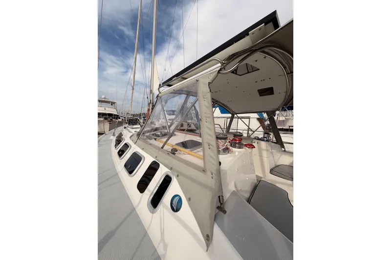 Slide: The Image of 2002 Hunter 460 sailboat cockpit with canopy, docked at marina under blue sky. - 10
