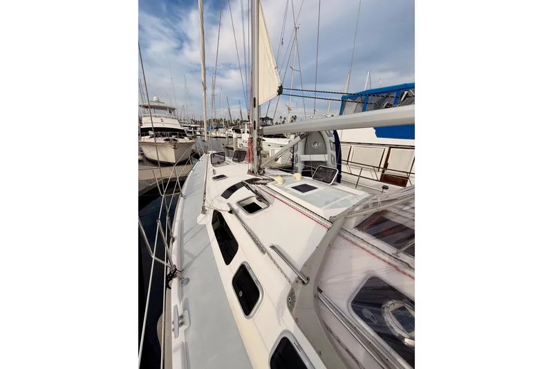 Slide: The Image of 2002 Hunter 460 sailboat docked at marina, showcasing deck and rigging. - 11