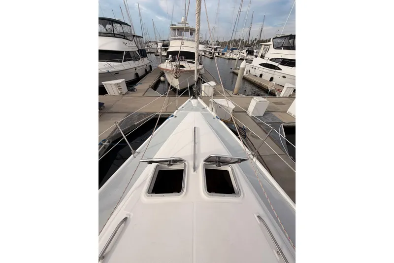 Slide: The Image of Hunter 460 sailboat from 2002 docked at a marina, surrounded by other boats. - 13