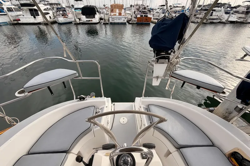 Slide: The Image of 2002 Hunter 460 sailboat cockpit view in marina, surrounded by docked boats. - 21