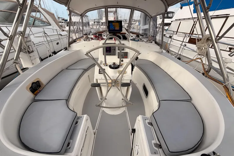 Slide: The Image of 2002 Hunter 460 sailboat cockpit with cushioned seating and navigation equipment. - 24