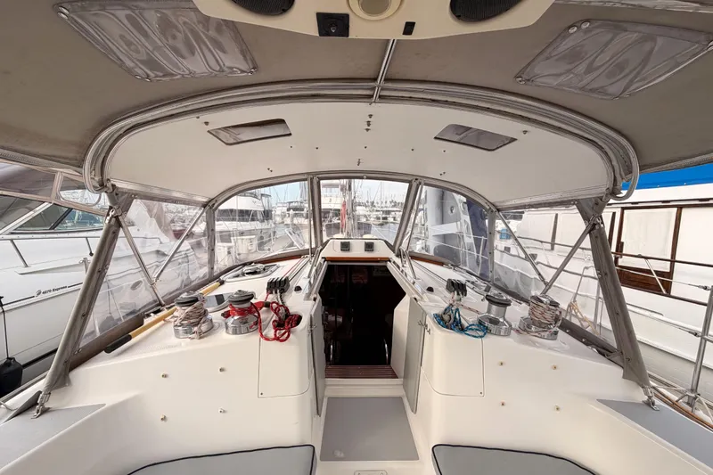 Slide: The Image of 2002 Hunter 460 yacht cockpit with winches and ropes, docked at a marina. - 27