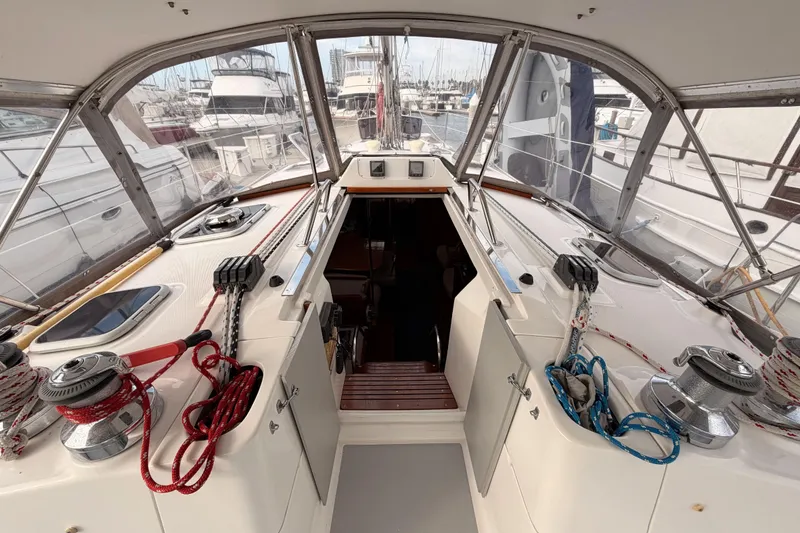 Slide: The Image of Interior view of a 2002 Hunter 460 sailboat cockpit with marina background. - 28