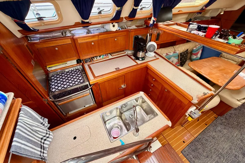 Slide: The Image of Interior of 2002 Hunter 460 sailboat kitchen with wood cabinetry and appliances. - 31