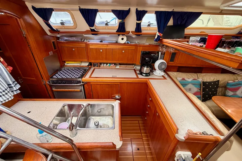 Slide: The Image of Cozy 2002 Hunter 460 yacht kitchen with wooden cabinetry and modern appliances. - 33
