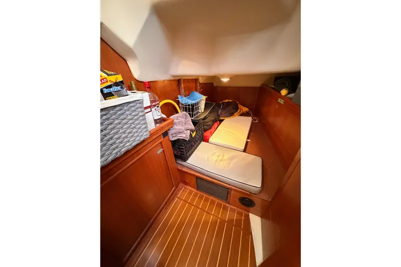 Slide: The Image of Cozy cabin interior of 2002 Hunter 460 sailboat with wooden finish and storage. - 38