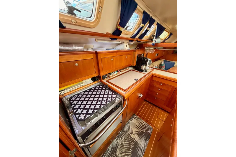 Slide: The Image of 2002 Hunter 460 yacht interior with wooden cabinetry and kitchen appliances. - 43
