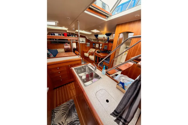 Slide: The Image of Interior of 2002 Hunter 460 sailboat, featuring a cozy cabin with wooden finishes. - 44