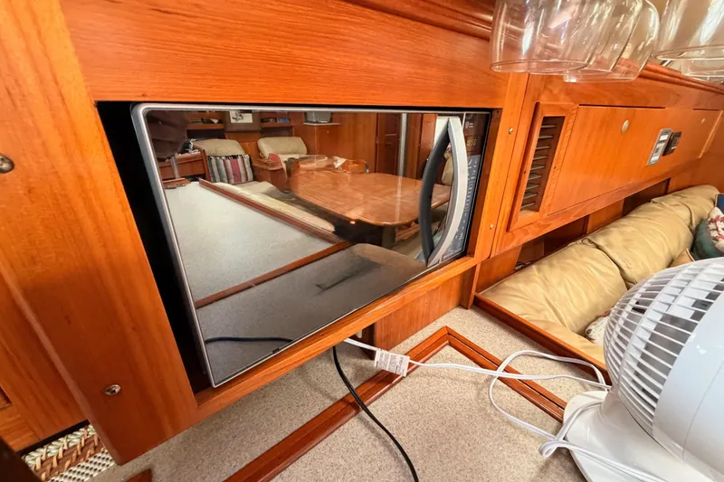 Slide: The Image of Interior of a 2002 Hunter 460 yacht with microwave and wooden cabinetry. - 46