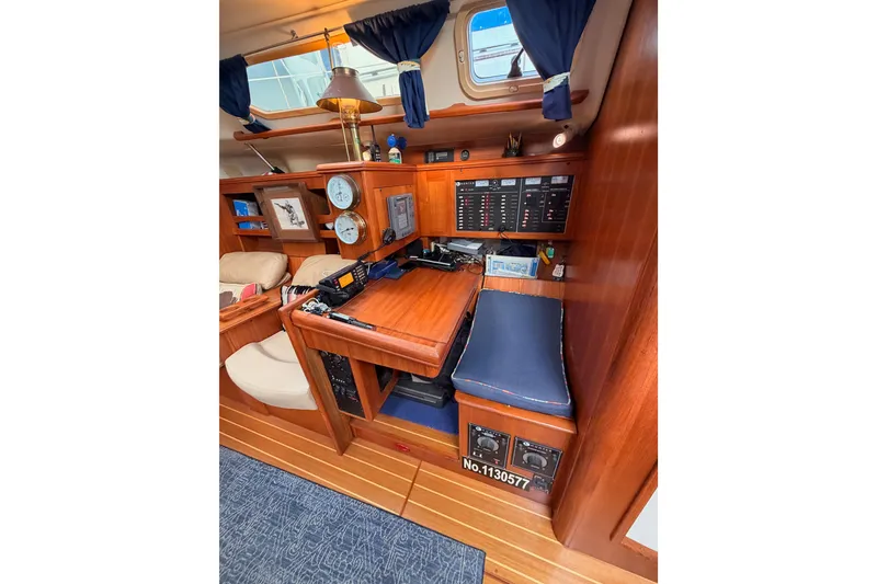 Slide: The Image of Interior of 2002 Hunter 460 sailboat with navigation station and wooden finish. - 48