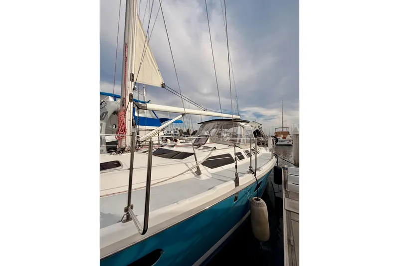 Slide: The Image of 2002 Hunter 460 sailboat docked at marina under cloudy sky. - 5