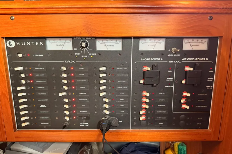 Slide: The Image of Electrical control panel of a 2002 Hunter 460 yacht, featuring various switches and meters. - 50