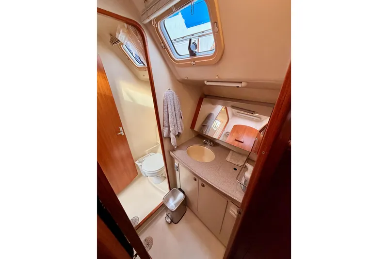 Slide: The Image of Interior of 2002 Hunter 460 yacht bathroom with sink, mirror, and toilet. - 62