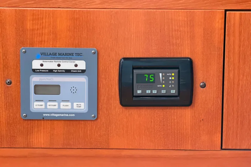 Slide: The Image of Control panels on a 2002 Hunter 460 yacht, featuring watermaker and temperature settings. - 66