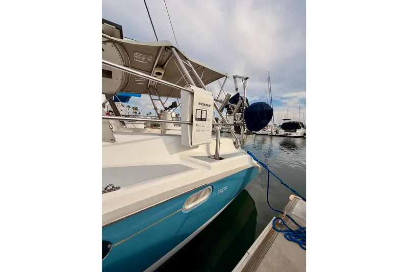 Slide: The Image of 2002 Hunter 460 sailboat docked in marina, featuring blue hull and white deck. - 7
