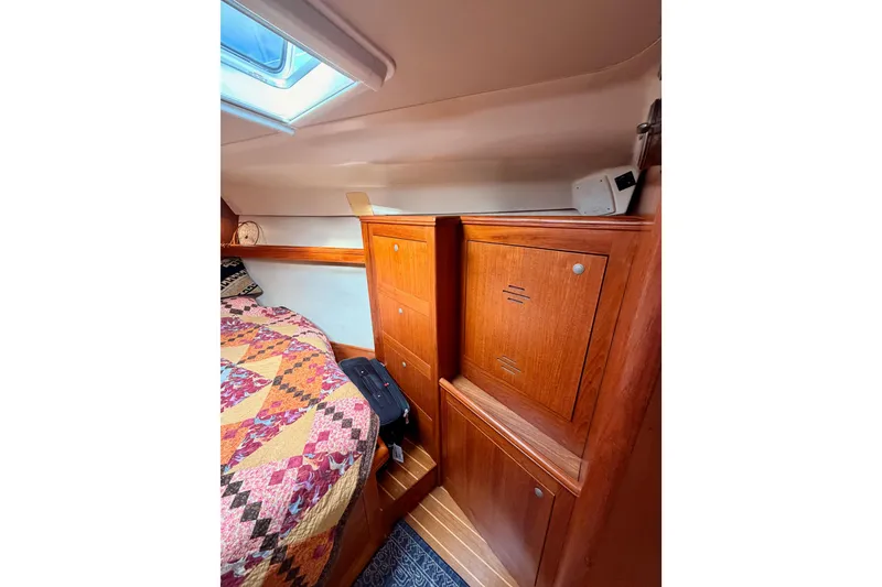Slide: The Image of Interior of 2002 Hunter 460 sailboat with wooden cabinets and colorful quilted bed. - 73