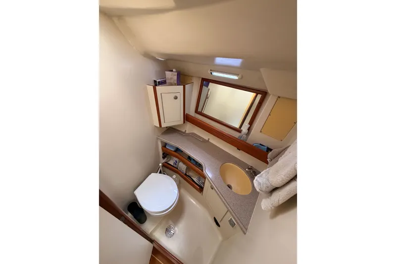 Slide: The Image of Compact bathroom in 2002 Hunter 460 yacht with sink, toilet, and storage cabinets. - 74