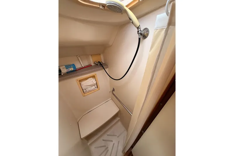 Slide: The Image of Compact shower area in a 2002 Hunter 460 sailboat, featuring a handheld showerhead. - 75