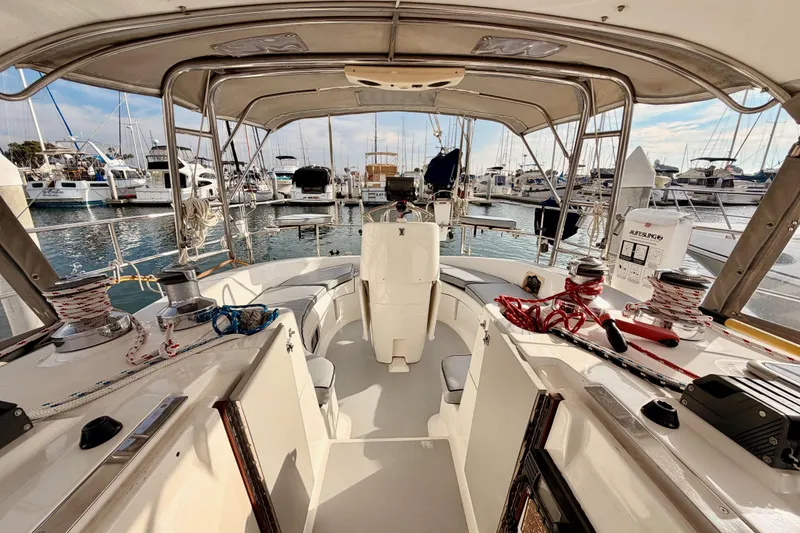 Slide: The Image of Cockpit view of 2002 Hunter 460 sailboat docked at marina, showcasing seating and equipment. - 81