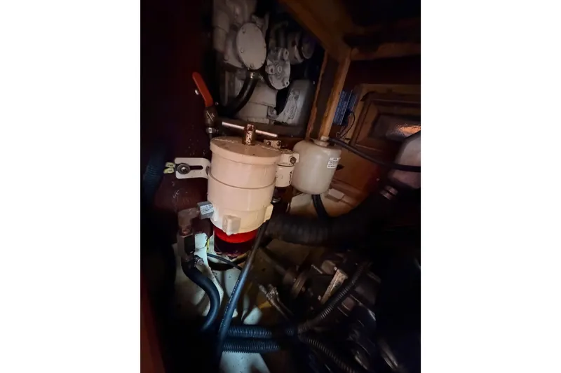 Slide: The Image of Engine compartment of a 2002 Hunter 460 sailboat, showing mechanical components and hoses. - 90