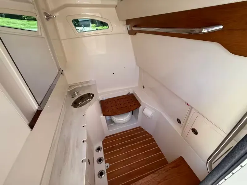 Slide: The Image of 2026 Grady-White Canyon 326 boat interior with sink, toilet, and wooden accents. - 14