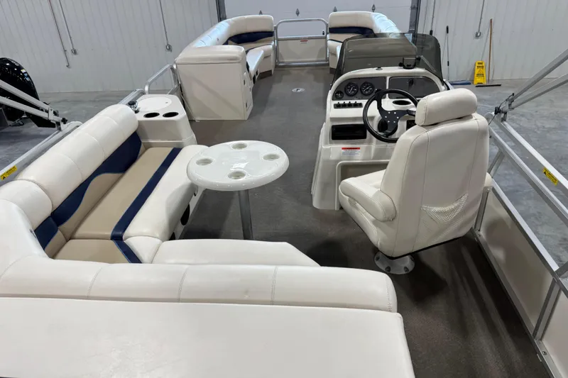 Slide: The Image of Interior of a 2005 G3 pontoon boat with white seating and steering console. - 15