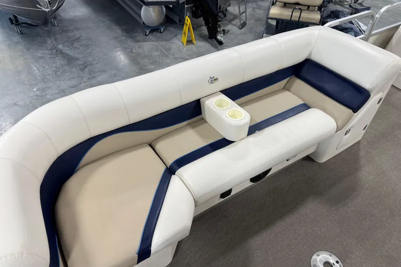 Slide: The Image of Luxurious 2005 G3 SunCatcher boat seating with cup holders, featuring beige and navy upholstery. - 8
