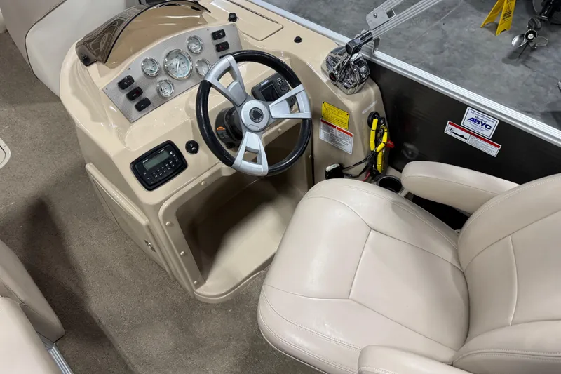 Slide: The Image of 2013 Crest 22 Crest II XRS boat dashboard with steering wheel and beige captain's chair. - 10