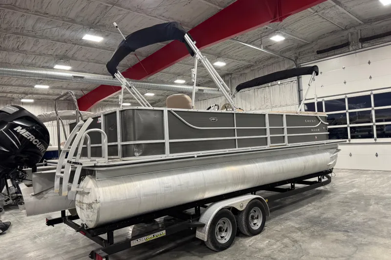 Slide: The Image of 2013 Crest 22 Crest II XRS pontoon boat on trailer in indoor storage facility. - 3