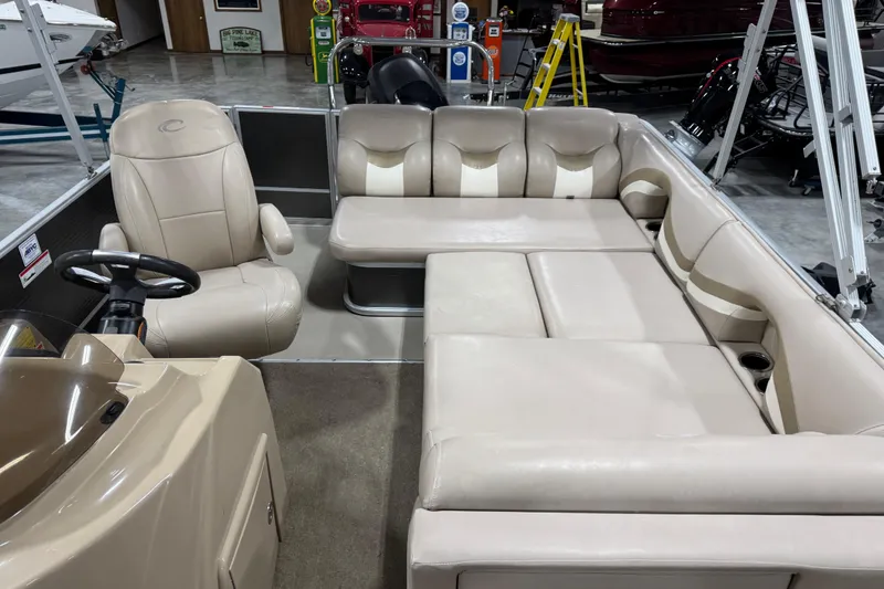 Slide: The Image of 2013 Crest 22 Crest II XRS pontoon boat interior with beige seating and steering console. - 7