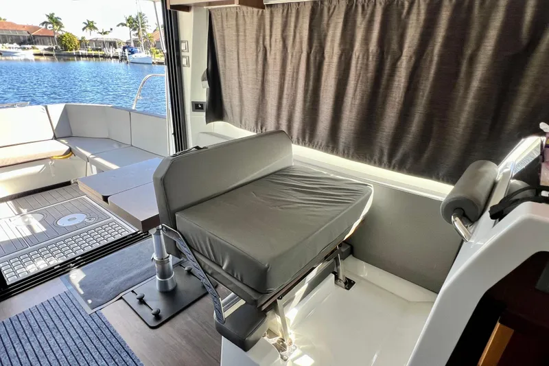 Slide: The Image of 2024 Beneteau Antares 11 interior with seating, table, and waterfront view. - 15