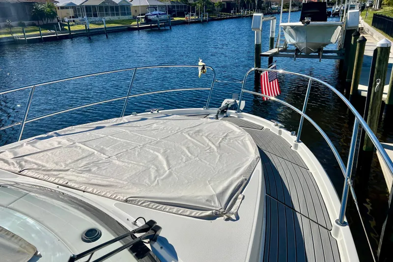 Slide: The Image of 2024 Beneteau Antares 11 boat docked, featuring a covered deck and American flag. - 16