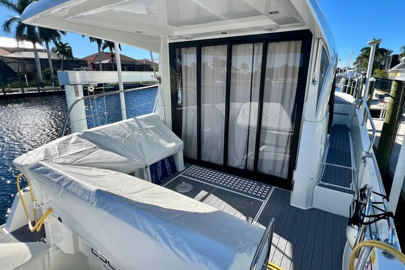 Slide: The Image of 2024 Beneteau Antares 11 yacht deck with covered seating and sliding glass doors. - 2