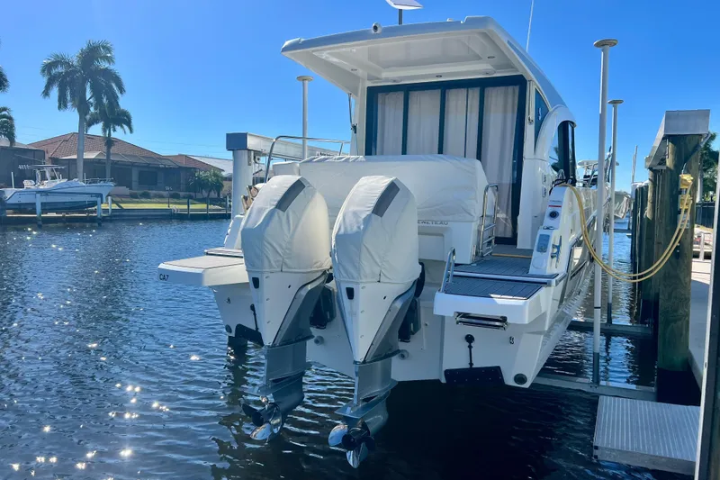 Slide: The Image of 2024 Beneteau Antares 11 docked with dual outboard engines, sunny waterfront view. - 4