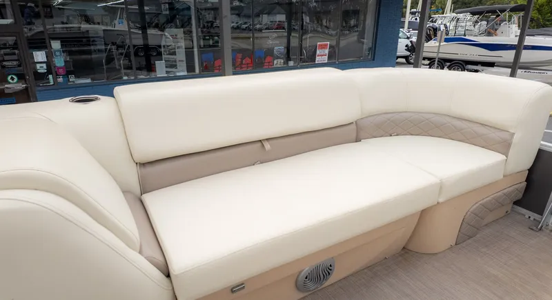 Slide: The Image of 2019 Sun Tracker 24 Party Barge interior with beige seating and cup holder. - 12