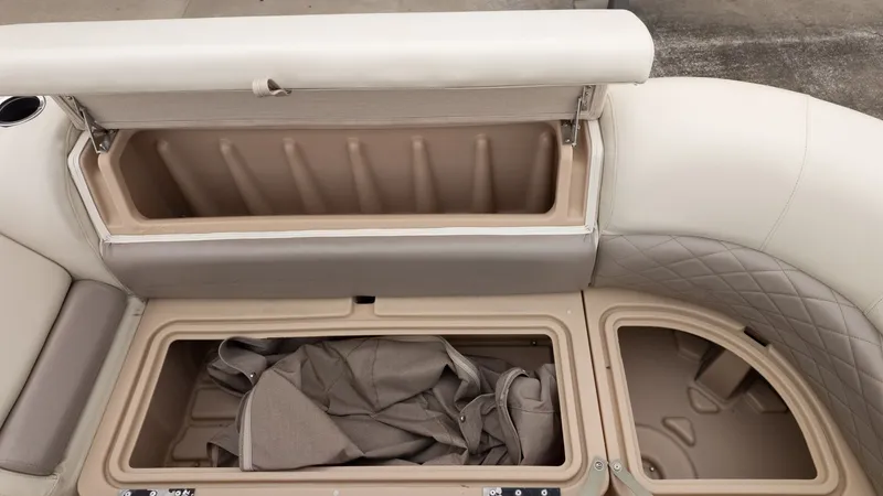 Slide: The Image of 2019 Sun Tracker 24 Party Barge storage compartments with beige upholstery and open lids. - 13