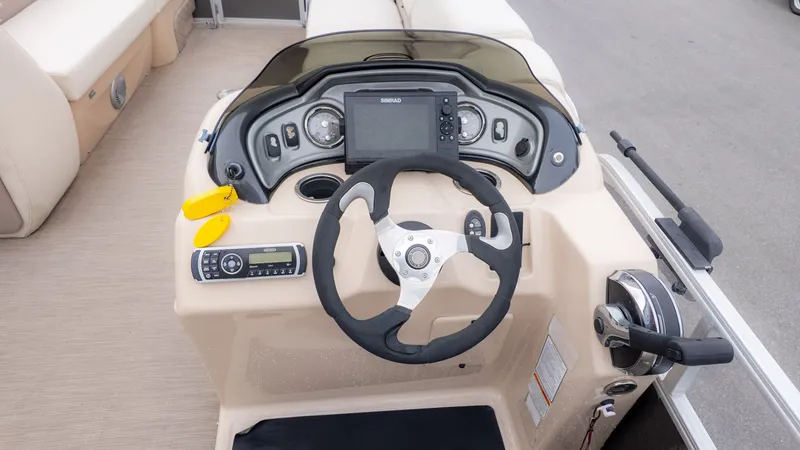 Slide: The Image of 2019 Sun Tracker 24 Party Barge dashboard with steering wheel and control panel. - 17